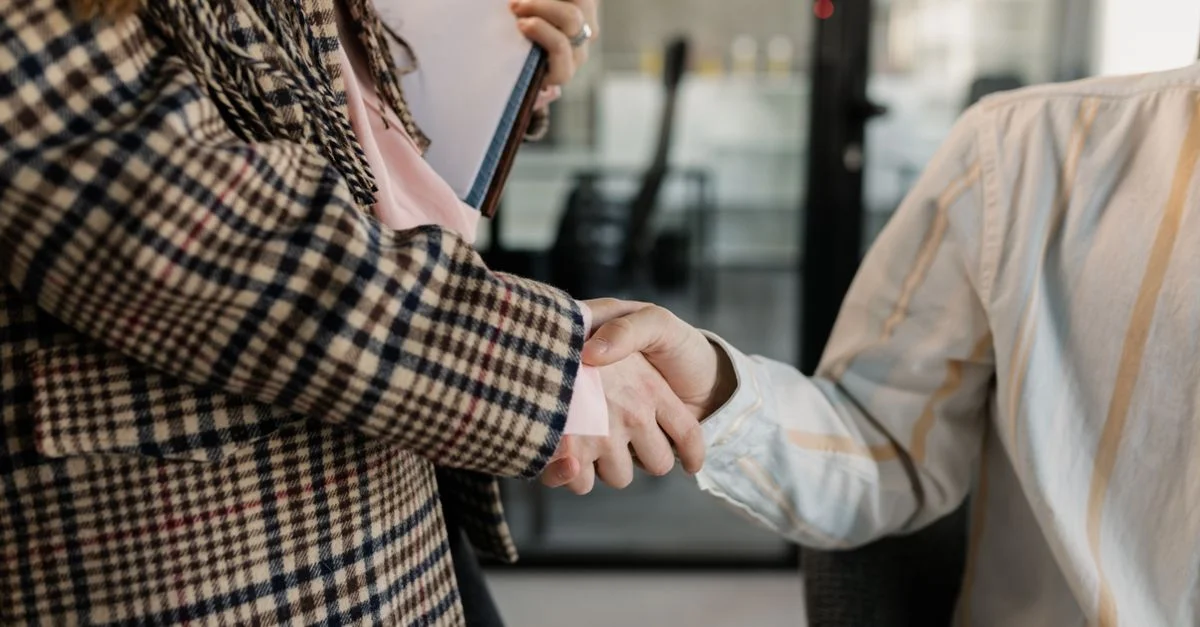 Gros plan sur une poignée de main entre deux professionnels dans un environnement de travail.