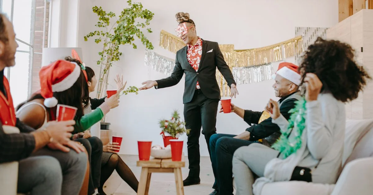 Des collègues profitent d'une fête de bureau de Noël avec des boissons et une décoration festive.