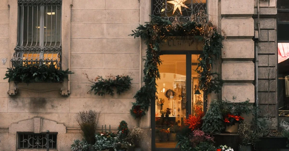Charmante façade de magasin ornée de décorations festives et de plantes en pot, en milieu urbain.
