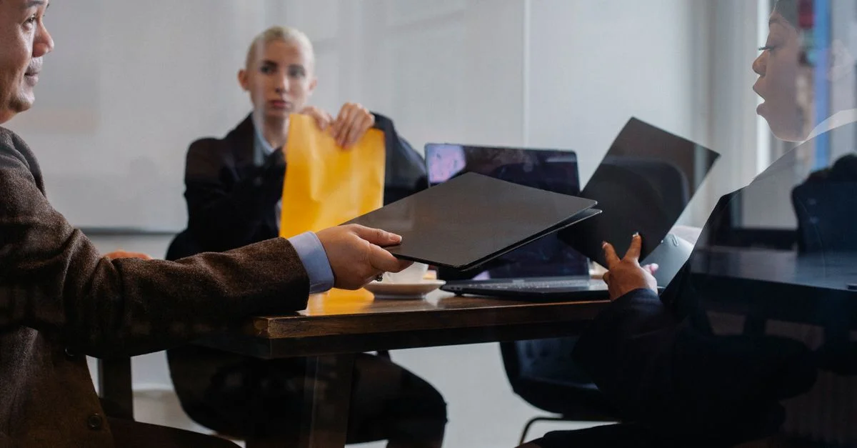Équipe professionnelle collaborant sur un projet dans un cadre de bureau moderne, partageant des documents.