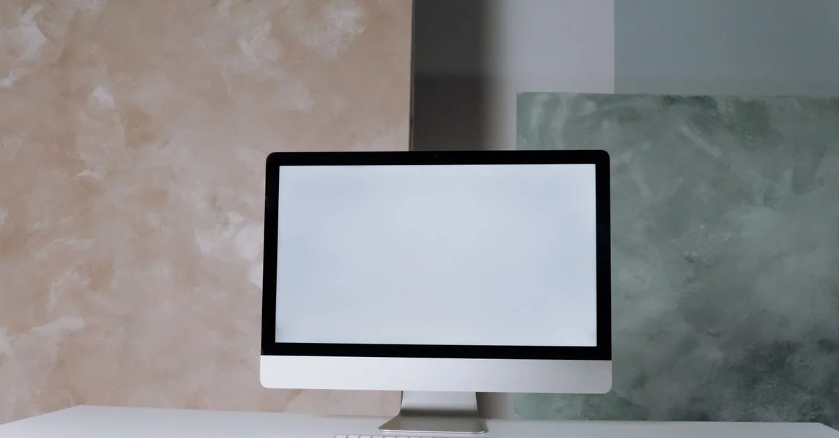 Configuration de bureau élégante avec un écran d'ordinateur, un clavier et une souris sur un fond abstrait moderne.