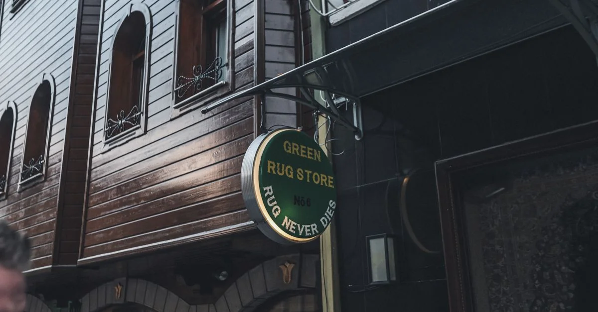 Une rue de la ville avec une façade en bois et une enseigne de magasin de tapis.