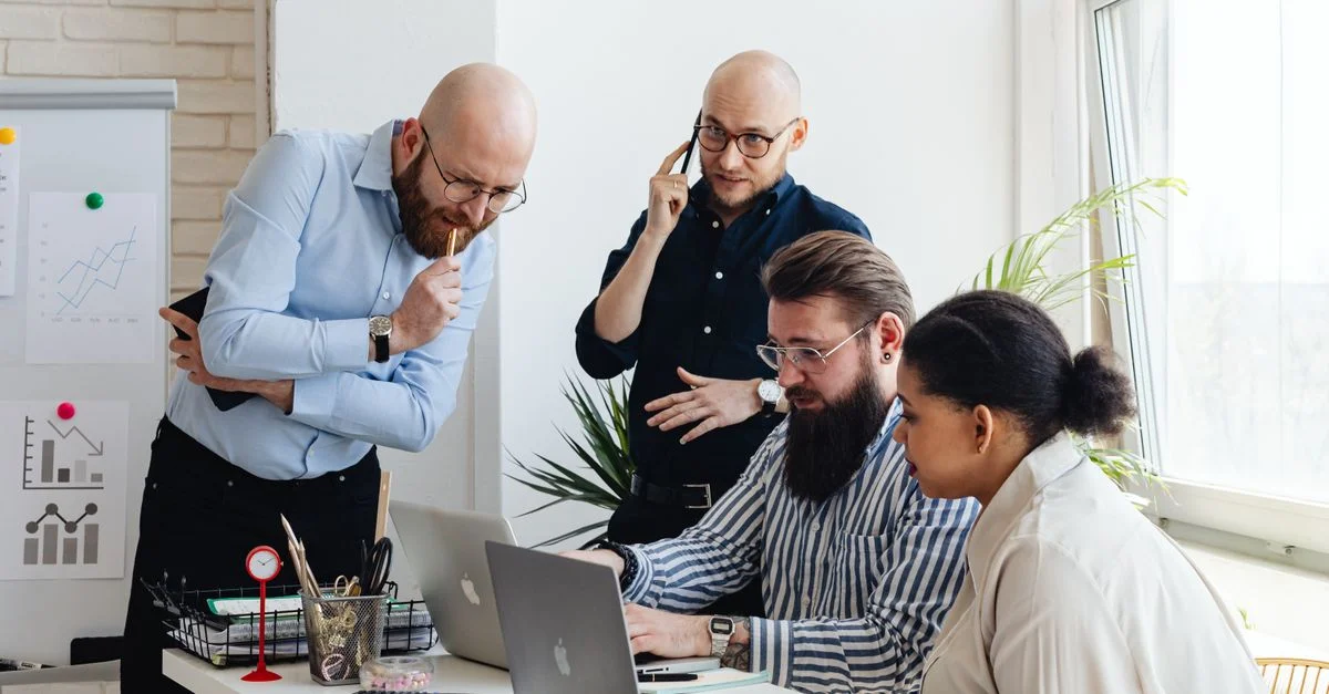 Une équipe multiethnique collabore sur un projet dans un environnement de bureau moderne, renforçant le travail d'équipe.