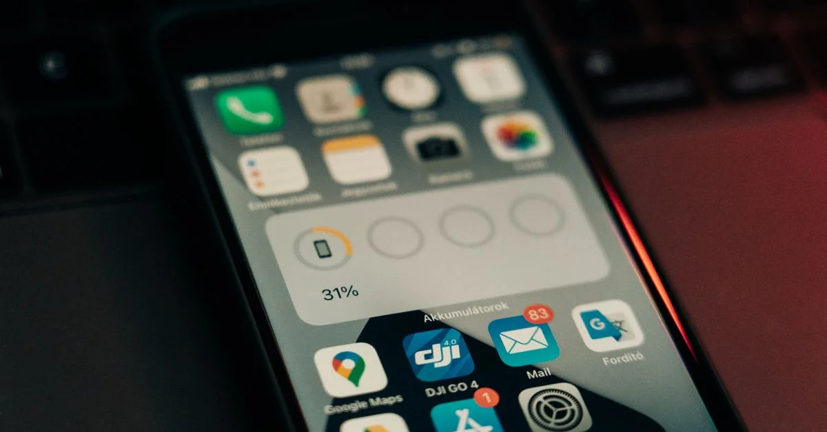 Un smartphone avec diverses applications sur son écran posé sur un clavier, affichant un niveau de batterie de 31 %.