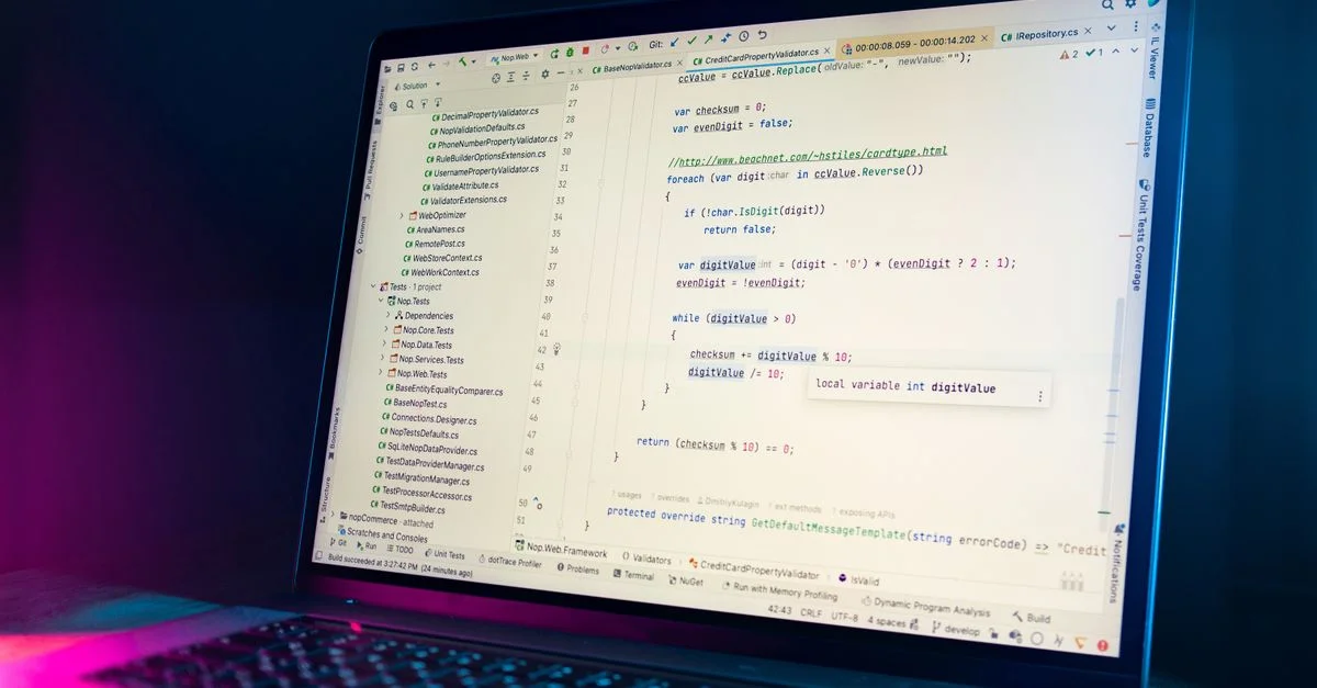Un écran d'ordinateur portable montrant un éditeur de code avec du code de programmation visible dans un environnement faiblement éclairé.