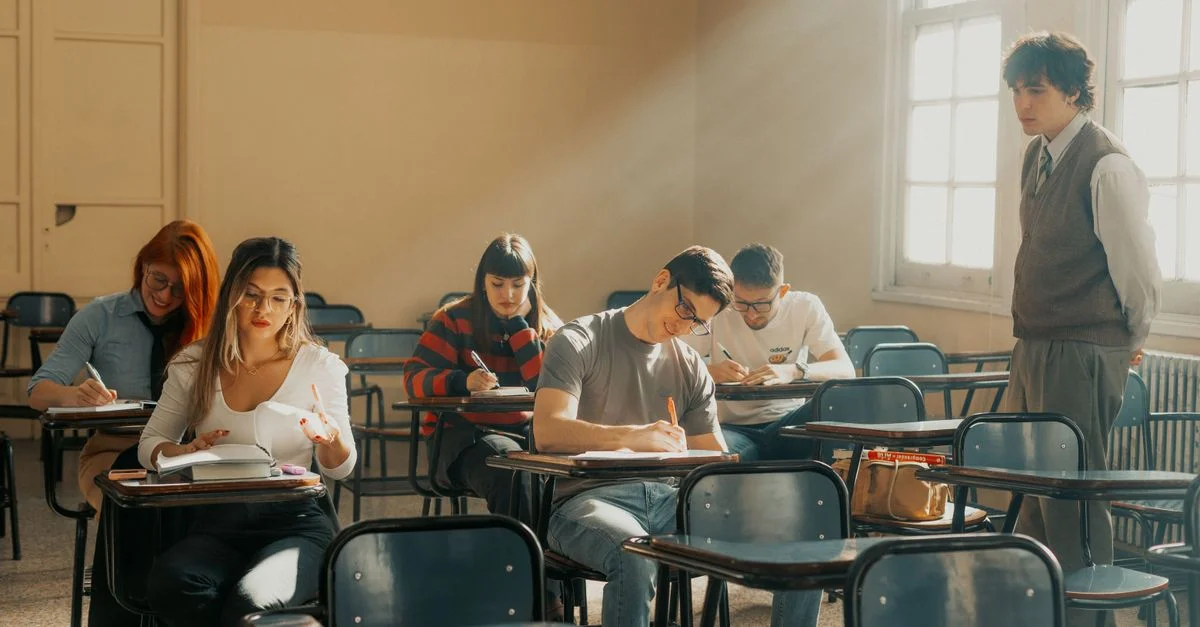 Des étudiants assistent à un cours dans une salle de classe d'une université de Buenos Aires, baignée de lumière naturelle.