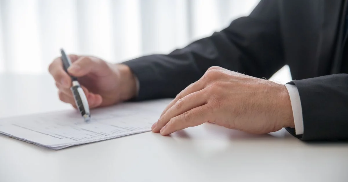 Homme d'affaires signant des documents importants à son bureau.