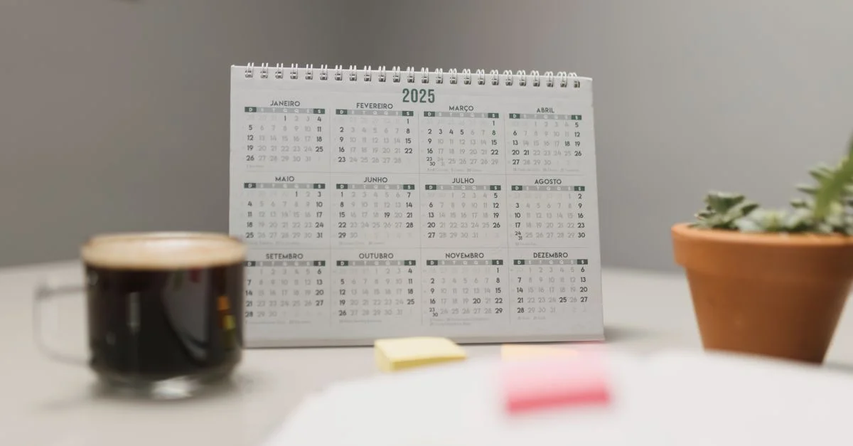 Un calendrier de bureau 2025 avec café et plantes succulentes, idéal pour la planification et la décoration du bureau.