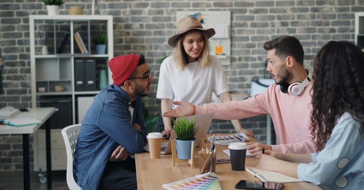 Groupe de jeunes professionnels brainstorming des idées dans un environnement de bureau moderne.