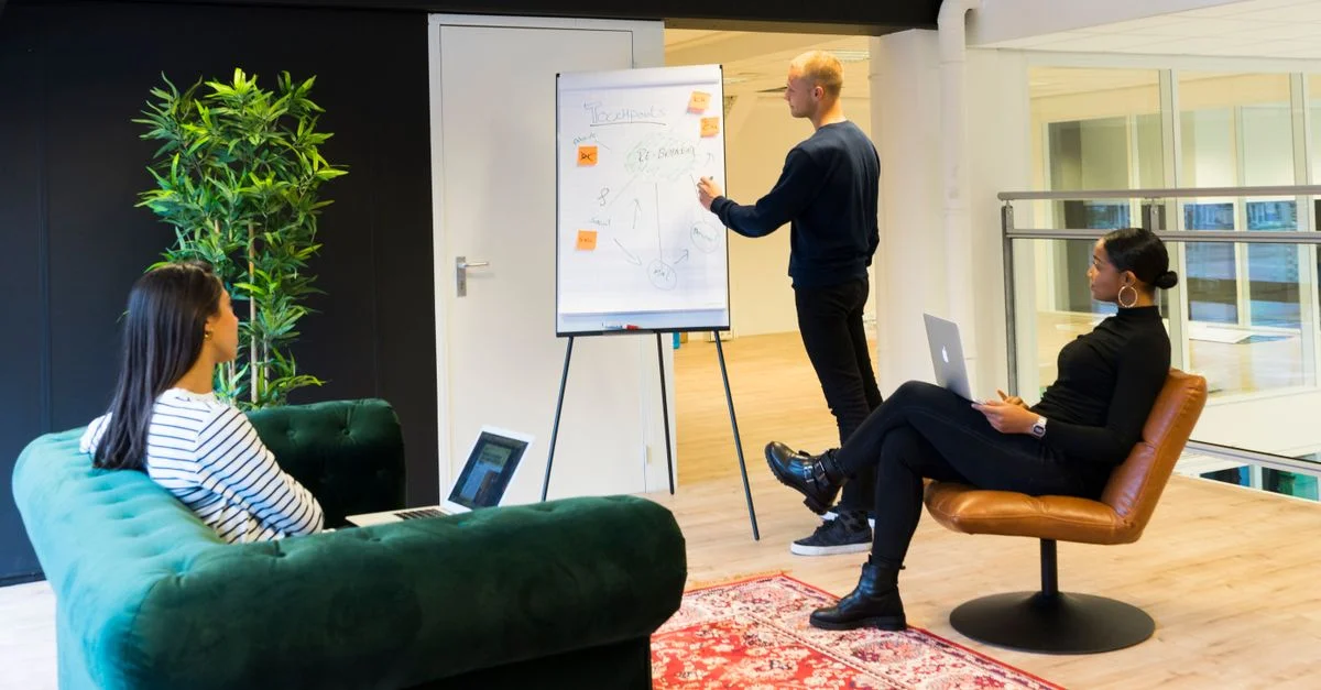 Un groupe de professionnels engagés dans une réunion collaborative dans un environnement de bureau moderne et lumineux.