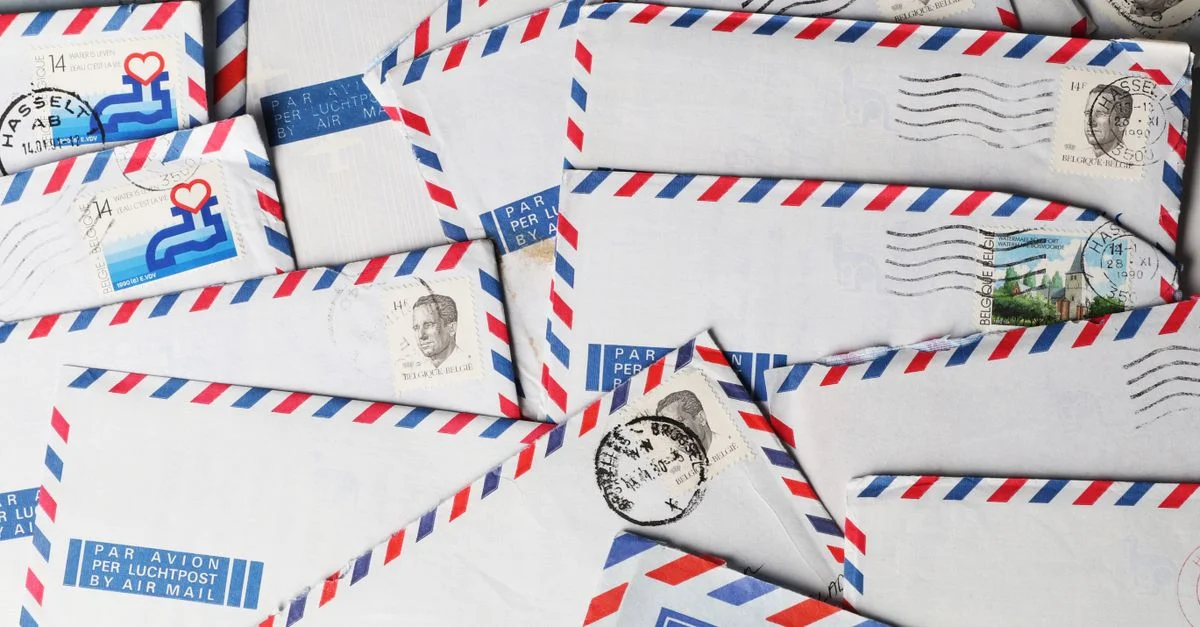Un gros plan d'enveloppes anciennes par avion avec des timbres et des cachets postaux, mettant en avant un design nostalgique.
