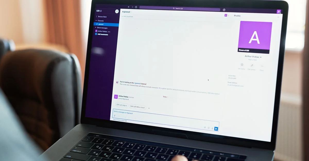 Personne utilisant un ordinateur portable avec une plateforme de communication en ligne, montrant la technologie de travail moderne.