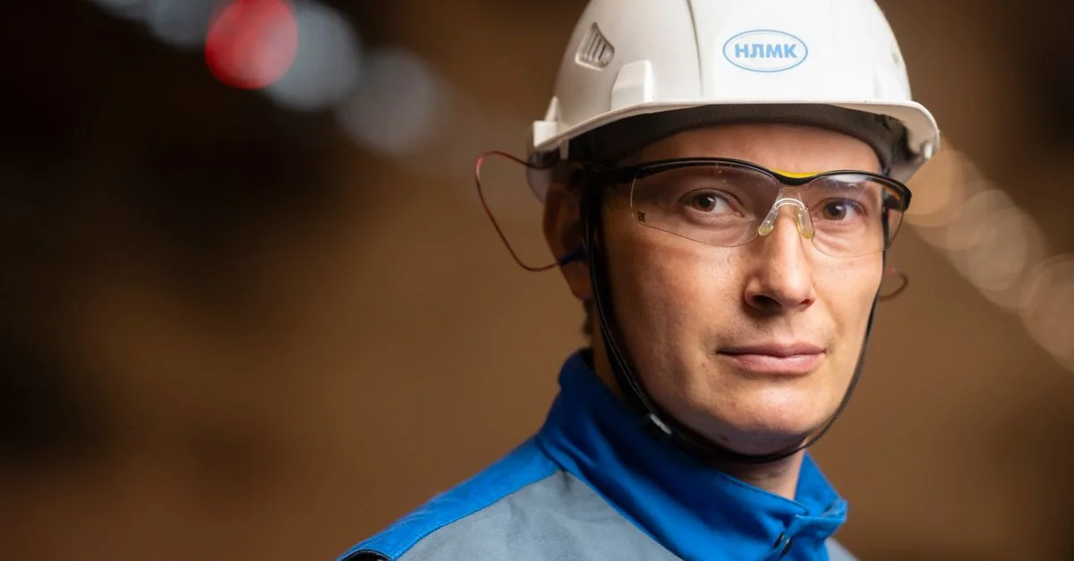 Ingénieur masculin confiant portant un casque de sécurité et des lunettes dans un cadre industriel.