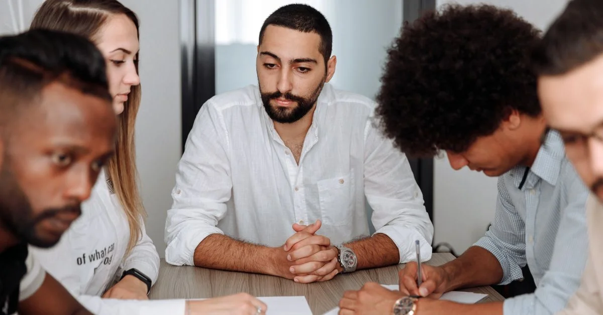 Une équipe diversifiée d'adultes collaborant lors d'une réunion de bureau, mettant en avant le travail d'équipe et le professionnalisme.