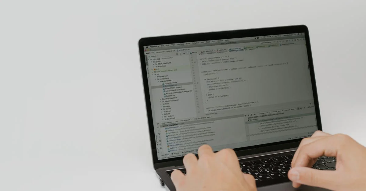 Mains tapant du code sur un ordinateur portable dans un espace de travail. Cadre intérieur axé sur le développement logiciel.